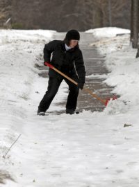 Žena odklízí sníh v Minneapolisu. Většinu USA zasáhly sněhové přívaly nečekaně brzy. Listopad 2014