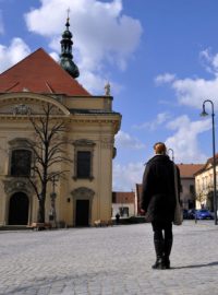 Žena stojící na Masarykově náměstí v Uherském Brodě poslouchá zvony, které se v poledne rozezněly na památku osmi obětí útoku v místní restauraci Družba