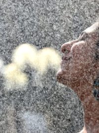 Mladá žena se osvěžuje na Staroměstském náměstí v Praze, kde odpoledne teplota vystoupala nad 38 °C