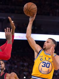 Hvězda Golden State Warriors Stephen Curry zakončuje přes obránce v zápase proti Toronto Raptors