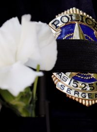 Smuteční páska s květinou na odznaku jednoho z dallaských policistů