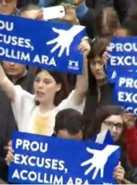 Demonstranti drželi plakáty s nápisy v katalánštině jako &quot;Už žádné výmluvy, přivítejme je hned!&quot;