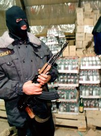 Příslušník zvláštní jednotky ruské policie hlídkuje u nelegálně vyrobené vodky (snímek z roku 1998)
