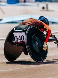 Atletka na závodní dráze pro vozíčkáře v paraatletické soutěži