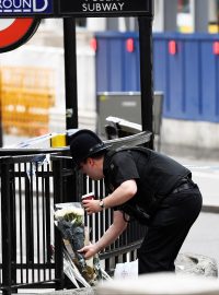 Policista pokládá květiny u stanice metra London Bridge