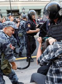 Příslušník národní gardy útočí na protestujícího muže při demonstraci za penzijní reformu v Moskvě