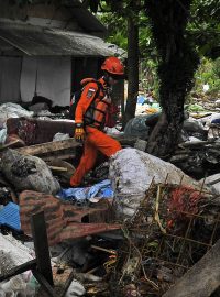 Záchranář prohledávající trosky po tsunami, která zpustošila indonéské pobřeží Sundského průlivu