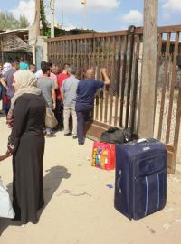 Na zavřené bráně z pletiva visí několik Palestinců, kteří se potřebují dostat do Egypta. Dnes už mají smůlu. Mnozí už několikátý den.