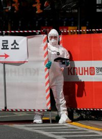 Zdravotní pracovník u brány místa testování na koronavirus v jihokorejském městě Tegu