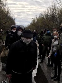 Váleční zajatci v ochranných maskách při výměně vězňů mezi Ukrajinou a separatisty.