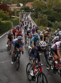 Peloton ve stoupání na mokré cestě.
