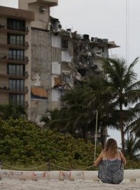 Žena sedící před zhroucenou budovou v Miami