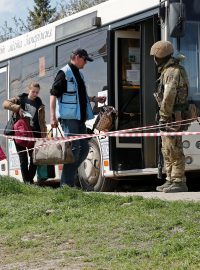 Civilisté z oblasti nedaleko Azovstalu nastupují do autobusu v dočasném ubytovacím centru u obce Bezimenne