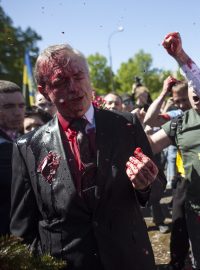 Demonstranti proti válce na Ukrajině polili diplomata rudou barvou, když chtěl 9. května položit věnec k pomníku na hřbitově sovětských vojáků ve Varšavě