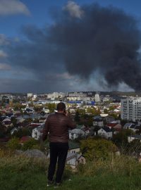 Muž pozoruje dým nad západoukrajinským Lvovem po zásahu ruskými raketami z 10. října 2022