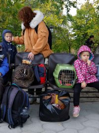 Civilisté, kteří uprchli z Chersonu, čekají na autobus. Míří na Krym