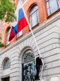 Muž sundává ruskou vlajku z Ruského domu v Kodani. Budova patři ruské ambasádě, která podléhá evropským sankcím (26. září 2023)