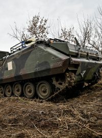 Voják 65. mechanizované brigády jde kolem svého obrněného vozidla YPR-765