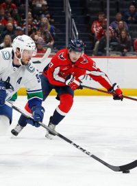 Dylan Strome z Washington Capitals pronásleduje J.T. Millera z Vancouver Canucks