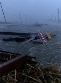 Trosky a voda po hurikánu Beryl pokrývají hlavní silnici v oblasti Surfside Beach v Texasu