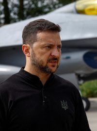 Ukrajinský prezident Volodymyr Zelenskyj hovoří s médii před bojovým letounem F-16 po oslavách Dne ukrajinského letectva uprostřed ruského útoku na Ukrajinu na neznámém místě na Ukrajině 4. srpna 2024