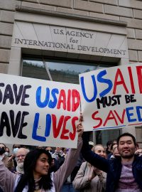 Protestující před budovou organizace USAID drží transparenty na její podporu