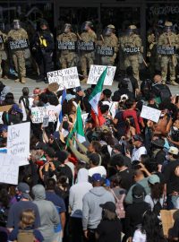 Demonstranti před budovou v Los Angeles, v níž sídlí řada federálních úřadů, nesli transparenty jako: „Stojím za všemi migranty“. Vchod střežili policisté a příslušníci Národní gardy