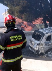 Hasič u trosek auta zničeného požárem v Chorvatsku nedaleko Splitu