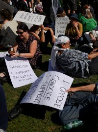 Účastníci protestu držící transparenty s nápisem „jsem proti genocidě. Podporuji Palestine Action“