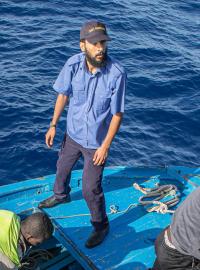 Migranti nastupují na loď libyjské pobřežní stráže.