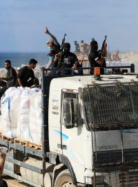 Palestinci z ozbrojených klanů jedou na kamionu s humanitární pomocí