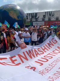 Hudba hraje, lidé jsou barevně oblečení, pohupují se do rytmu