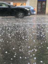 Krupobití v Praze na Vinohradské třídě. Kroupy pokryly celou ulici.