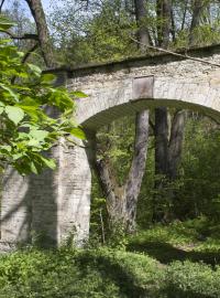 Původní brána do Lánské obory z opuky skrytá v lese poblíž silnice kolem obory, ta totiž byla v minulosti násobně větší