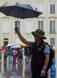 Turisté za deštivého počasí 29. června na třetím nádvoří Pražského hradu.