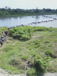 Migranti zejména ze Salvadoru překračující mělkou část hraniční řeky mezi Mexikem a Guatemalou