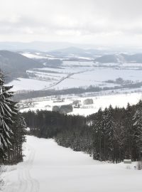 Pohled ze sjezdovky směrem k masivu Králického Sněžníku ve skiaerálu Buková hora v Červené Vodě na Ústeckoorlicku.