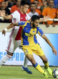 Hráč APOELu Nikósie Musa Suleimanduring si brání míč před Lisandrem Martinezem z nizozemského Ajaxu