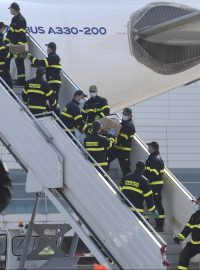 Hasiči vykládají letadlo, které v pátek přivezlo do Čech z Číny přes milion respirátorů FFP2