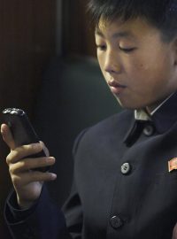 Chlapec používá chytrý telefon v metru v Pchjongjangu
