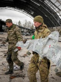 Ukrajinští vojáci nesou zbytky ruského útočného dronu na letišti Hostomel nedaleko Kyjeva