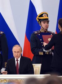 Vladimir Putin při ceremoniálním podepisování dokumentů o připojení ukrajinského území k Rusku