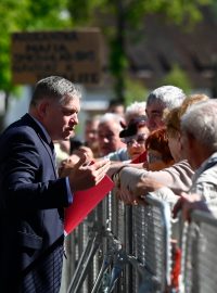 Premiér Robert Fico (Směr) zdraví místní obyvatele při příjezdu na zasedání vlády v Handlové