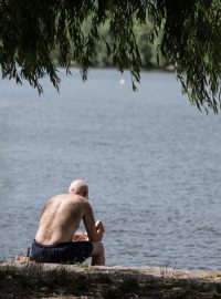 Lidé se opalují u Vltavy v Bráníku.