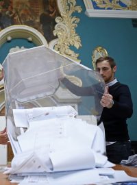 Členové volební komise v Moskvě vysypávají volební hlasy z urny.